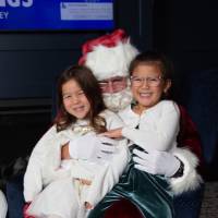 Girls smile on Santa's lap